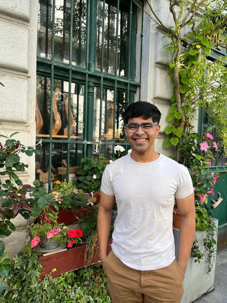 Apoorv Agnihotri smiling in front of a garden window